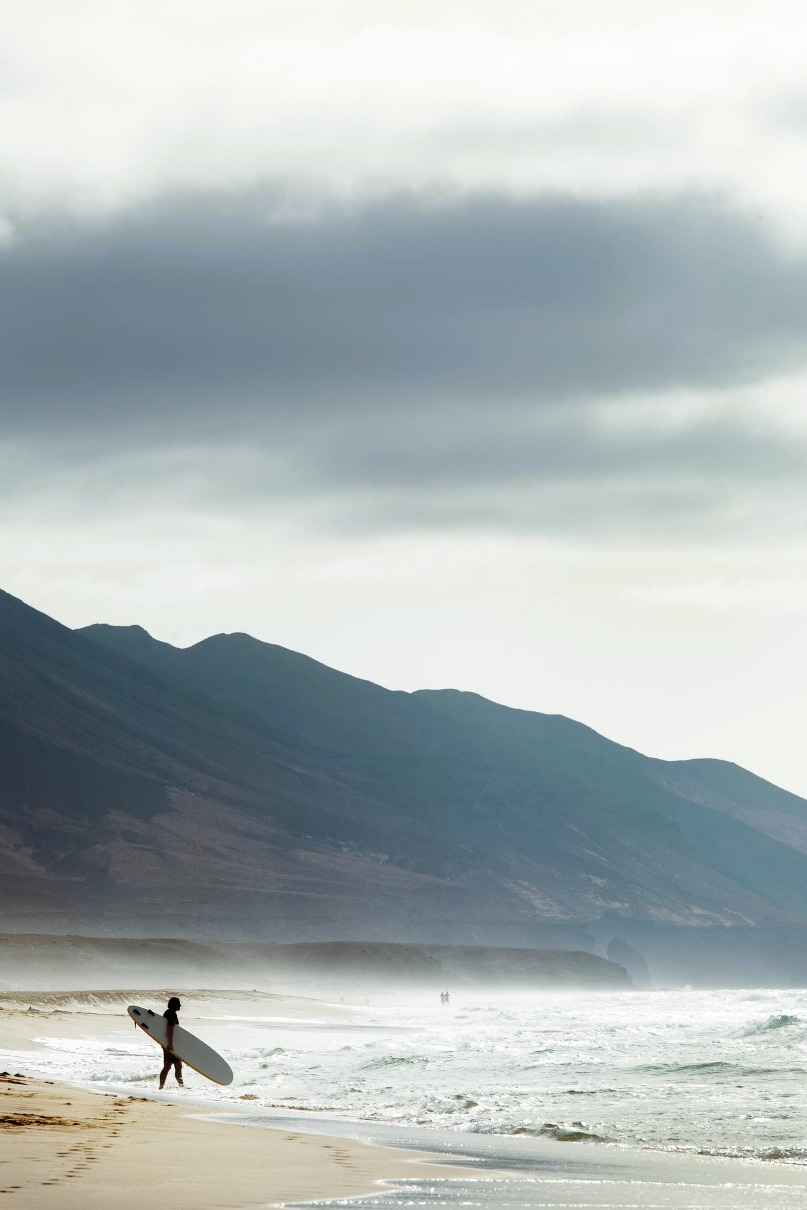 Surfer sur la plage de Cofete, Fuerteventura